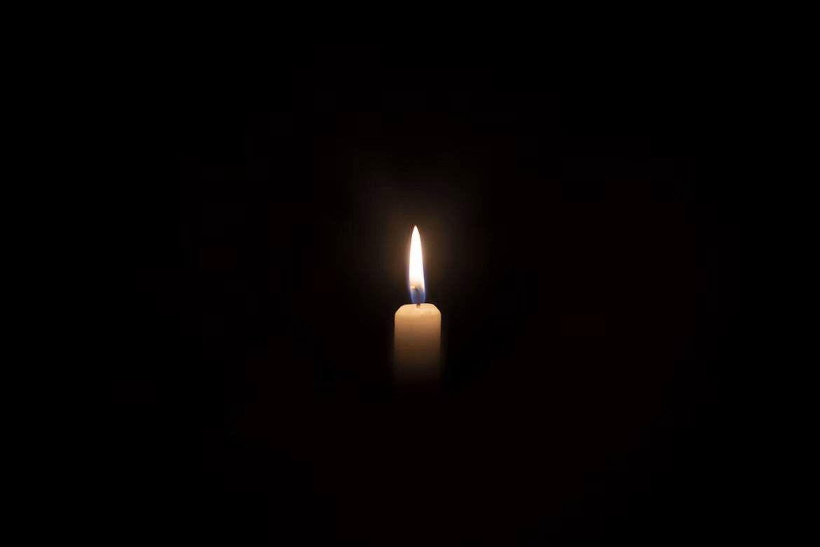 A single candle burning in complete darkness, the light that opens a dark retreat in Portugal